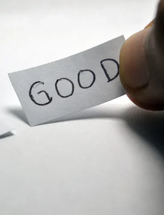 hand picking paper with the word GOOD beside another labeled BAD