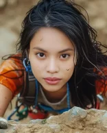 young woman climbing a mountain, focused and determined expression